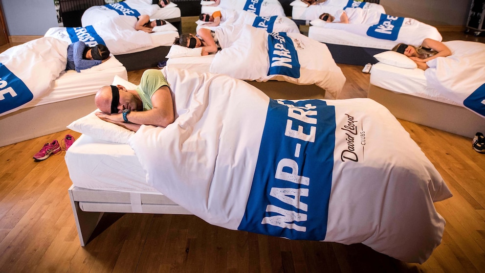 Eine Gruppe von Menschen hat sich in einem Fitnessstudio zu einem Napercise-Schalfkurs zusammengefunden