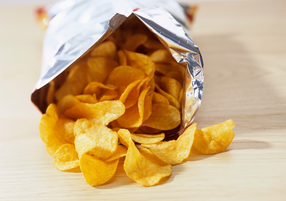 Eine offene Tüte Kartoffelchips liegt auf einem Tisch