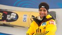 Bob-Pilotin Mariama Jamanka posiert f&uuml;r ein Foto vor einer Leinwand mit einer Rennsituation