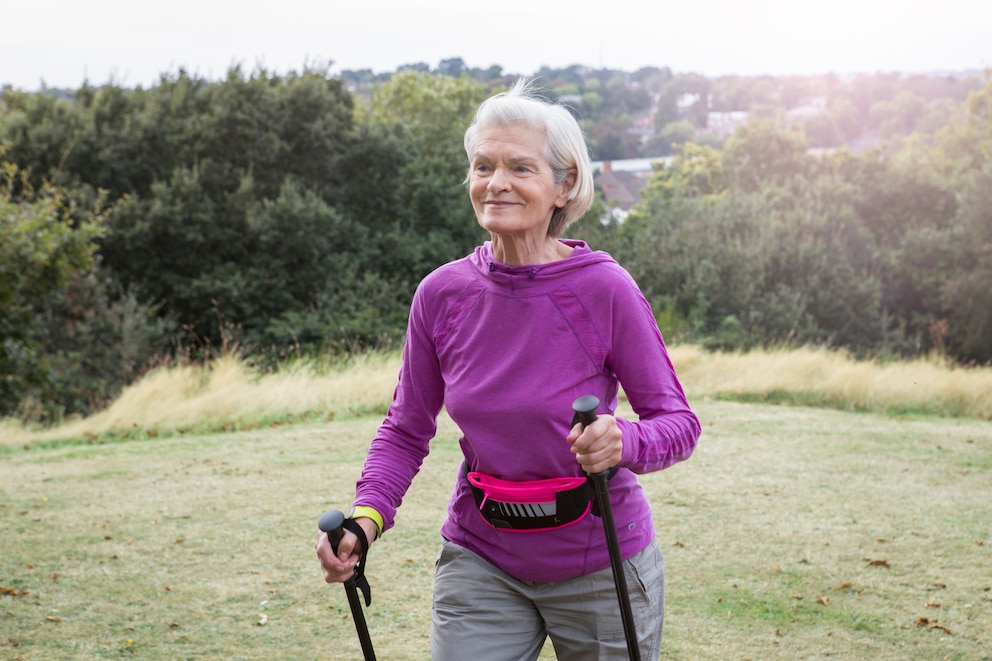 Eine ältere Dame beim Nordic Walking