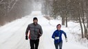 Eine Frau und ein Mann laufen durch eine winterliche Landschaft