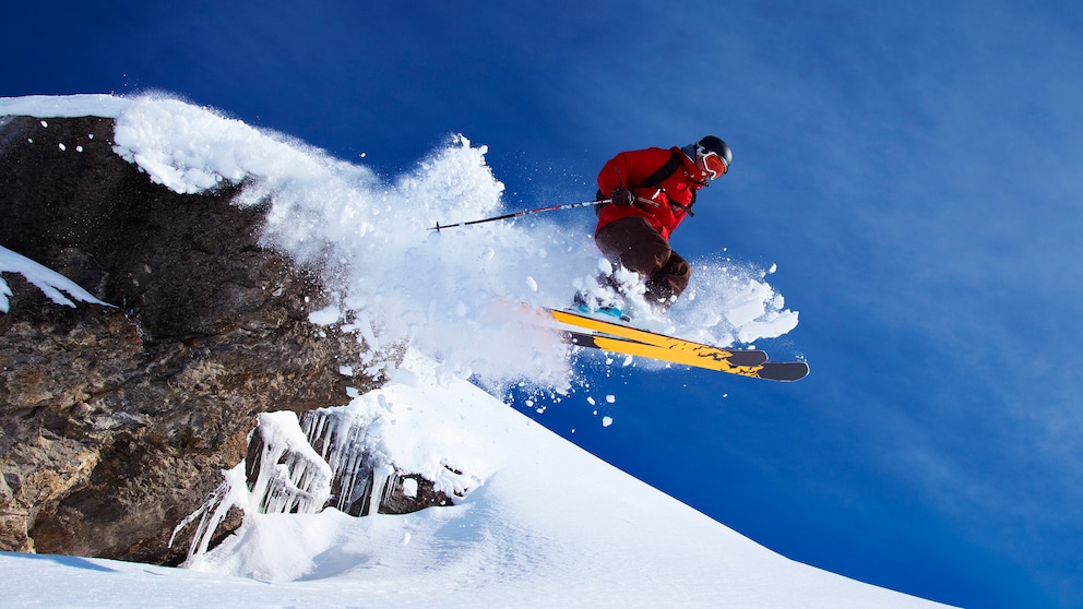 Ein Skifahrer springt über einen Felsvorsprung