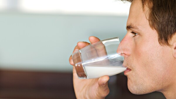 Mann trinkt Milch aus einem Glas