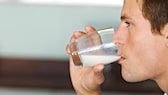 Mann trinkt Milch aus einem Glas