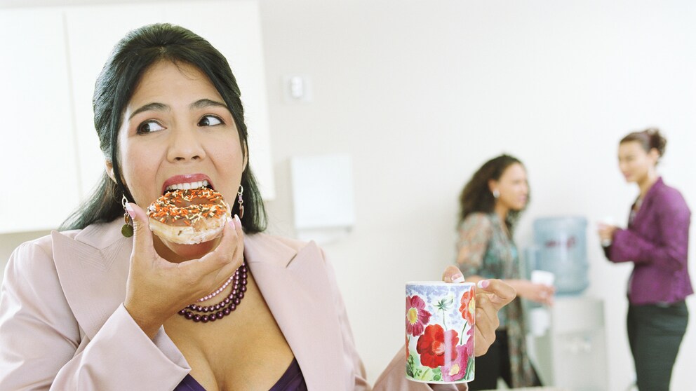 Büroangestellte isst Donut