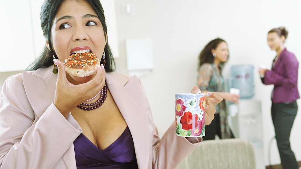 Büroangestellte isst Donut