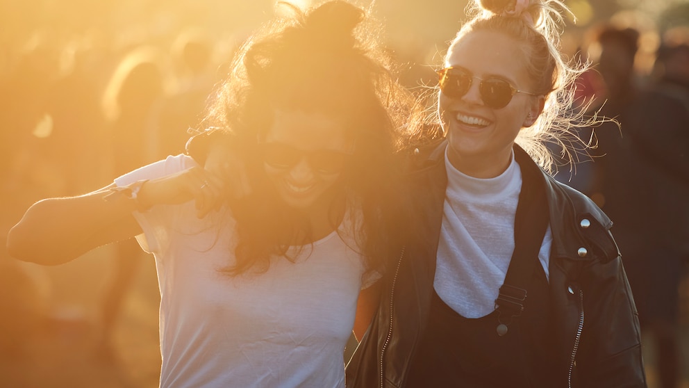 Zwei junge Damen umarmen sich bei Sonnenuntergang