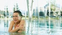 Eine Frau zittert in einem Swimmingpool