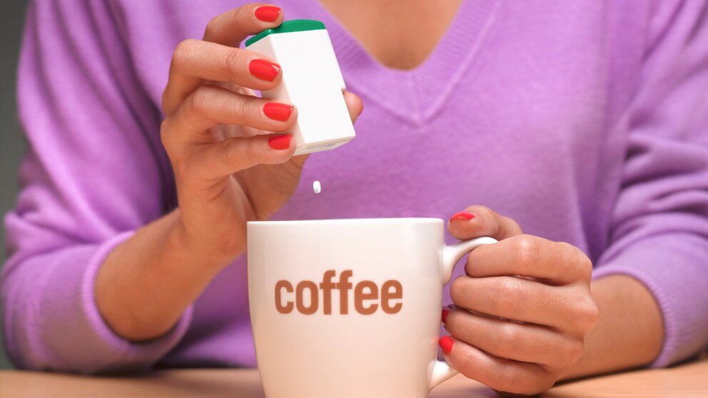 Eine Frau macht Süßstoff in ihren Kaffee