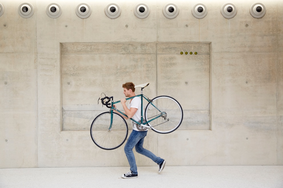 Mann trägt sein Fahrrad