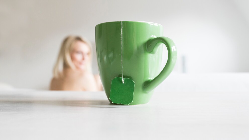 Grüne Tasse mit Teebeutel