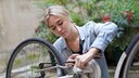 Eine junge Frau reinigt ihr Fahrrad