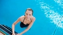 Eine Frau steigt in einen Swimmingpool