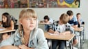 Schülerin schaut gedankenverloren in die Luft