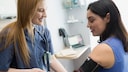 Lachende Ärztin misst Blutdruck