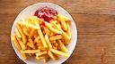 Eine Portion Pommes mit Ketchup auf einem Teller