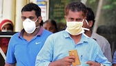 Zwei Männer schützen sich mit Gesichtsmasken in Indien vor dem Nipah-Virus