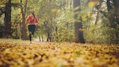 Frau joggt im Herbst