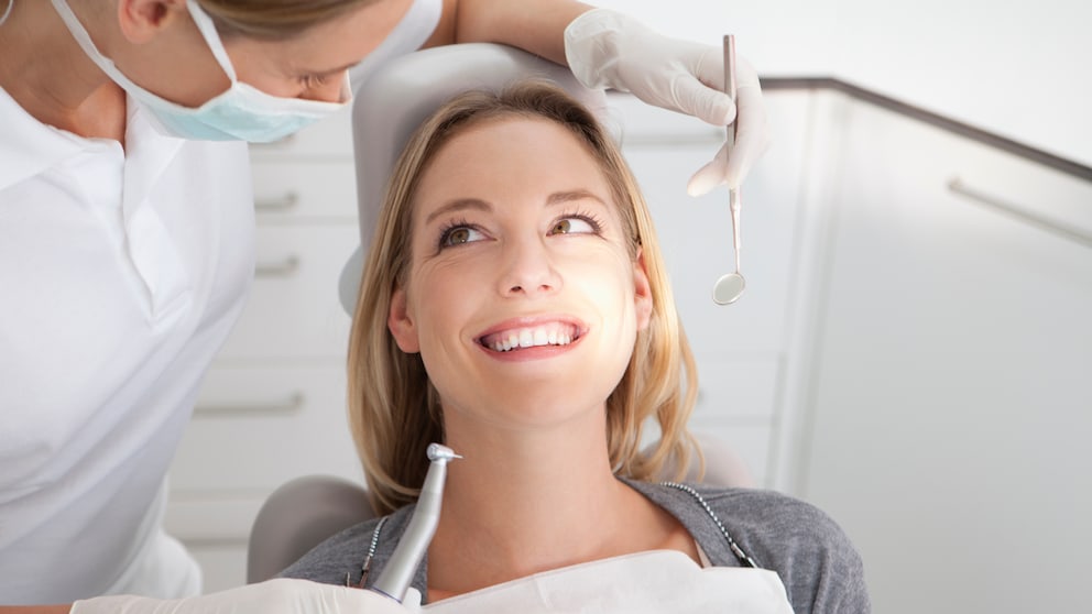 Eine junge Frau sitzt beim Zahnarzt