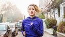 Eine junge Frau joggt auf einem Bürgersteig