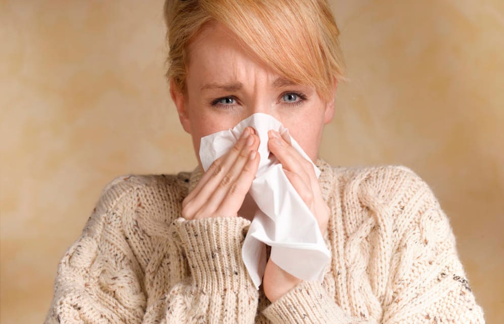 Junge Frau mit Erkältungssymptomen