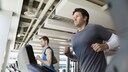 Ein junger Mann joggt auf einem Laufband in einem Fitnessstudio
