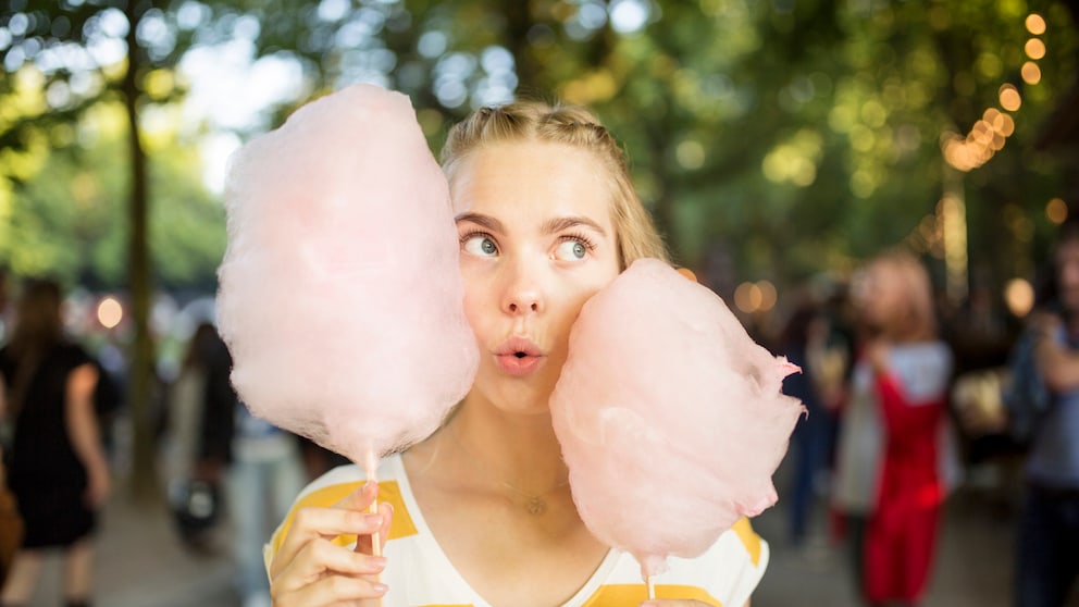 Junge Frau isst Zuckerwatte