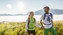 Ein junges Pärchen wandert glücklich durch die Berge