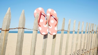 Flip Flops auf einem Zaun am Strand