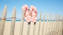 Flip Flops auf einem Zaun am Strand