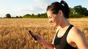 Eine sportliche Frau schaut auf ihr Smartphone