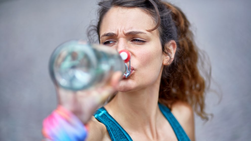 Frau trinkt aus Wasserflasche