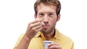 Mann isst Joghurt