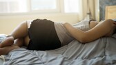 Frau im Bett mit Regelschmerzen
