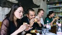 Junge Menschen bei&szlig;en mit offensichtlichem Genuss in einen Burger