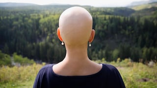 Eine Krebspatientin ohne Kopfhaare schaut in die Ferne