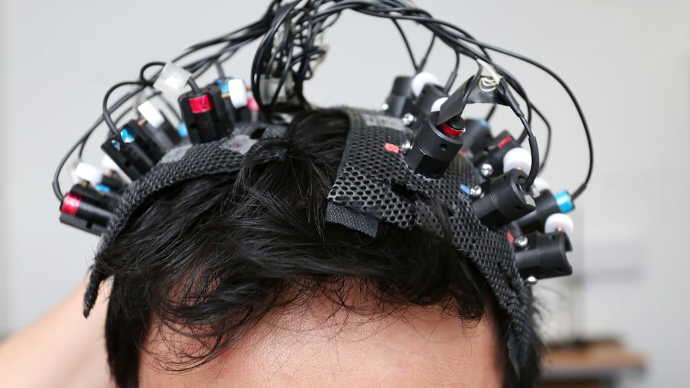 Viele Elektroden, befestigt auf einem Kopf mit schwarzen Haaren