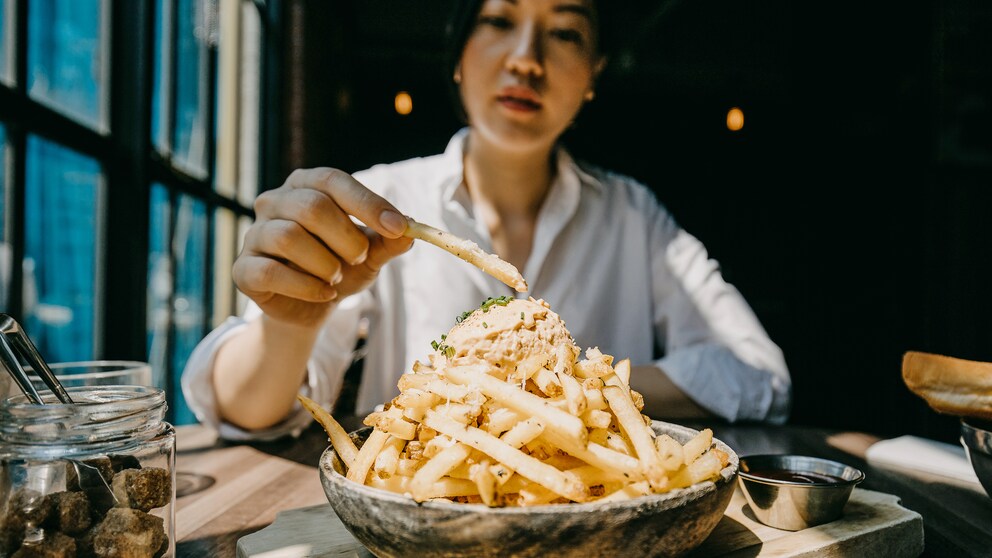 Junge Frau isst Pommes frites