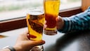 Zwei Männer stoßen mit Bier an