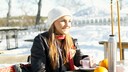 Eine junge Frau macht eine Skipause und trinkt etwas
