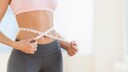 Frau mit Maßband um ihren Bauch