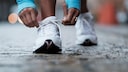 Eine Frau bindet sich die Laufschuhe