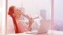 Eine Frau gähnt im Büro