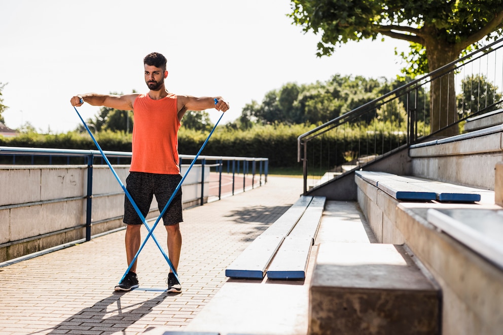 Man beim Trainieren mit Fitnessbändern