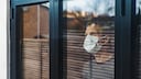 Mann mit Mundschutz hinter einem Fenster