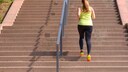 Eine Frau joggt Treppen hinauf