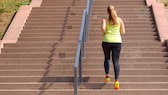 Eine Frau joggt Treppen hinauf