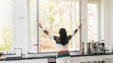 Lüften: Eine Frau öffnet das Küchenfenster