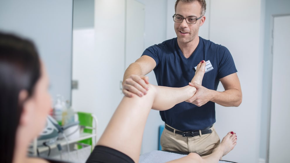 Eine Frau wird von einem Physiotherapeuten behandelt