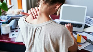 Frau mit Nackenschmerzen im Homeoffice